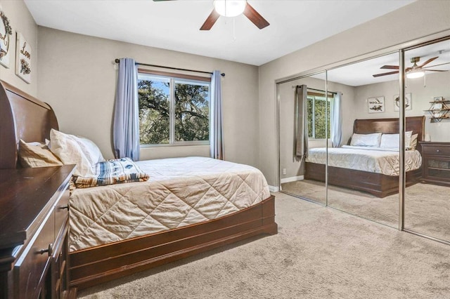 bedroom with ceiling fan, a closet, and light colored carpet