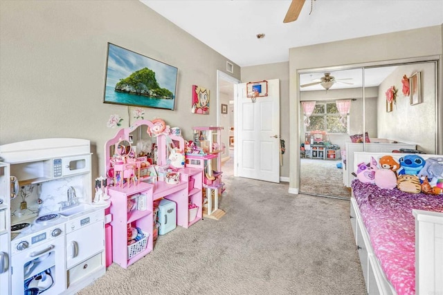 bedroom featuring ceiling fan, light carpet, and a closet