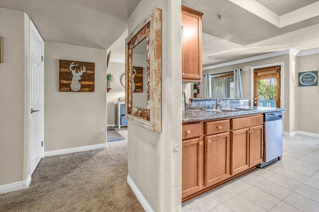 kitchen featuring dishwasher, sink, light stone countertops, ornamental molding, and light colored carpet