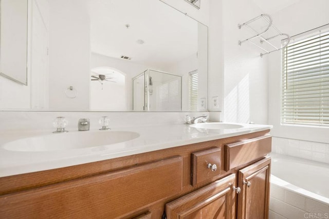 bathroom featuring ceiling fan, vanity, and shower with separate bathtub