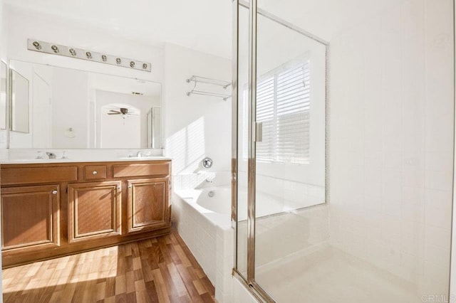 bathroom featuring hardwood / wood-style flooring, ceiling fan, vanity, and independent shower and bath