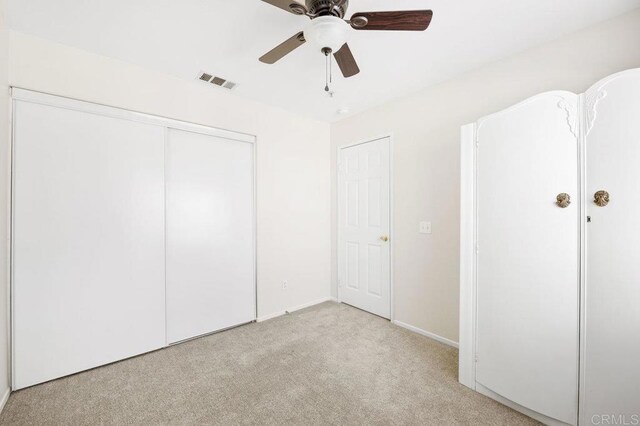 unfurnished bedroom with ceiling fan, a closet, and light colored carpet