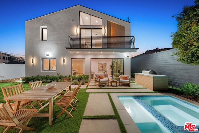 back house at dusk featuring a balcony, outdoor lounge area, a fenced in pool, and a patio