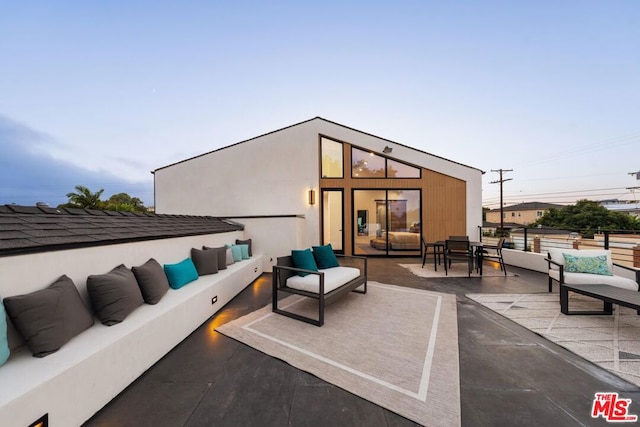 patio terrace at dusk featuring an outdoor living space