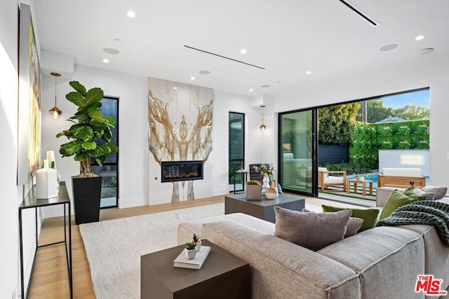 living room with light wood-type flooring and a high end fireplace