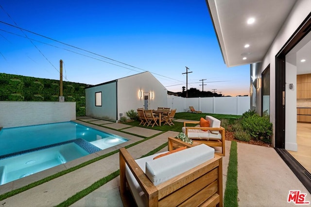 pool at dusk featuring a patio area