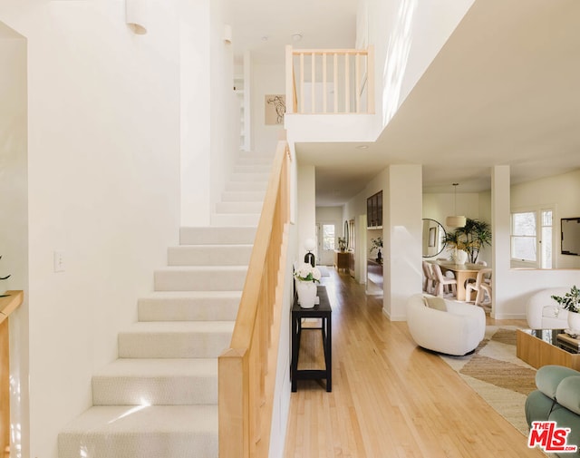 stairway featuring a healthy amount of sunlight and hardwood / wood-style floors