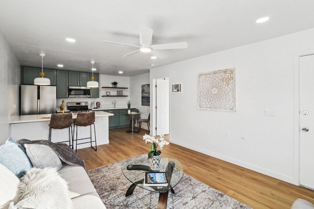 living room with light wood-type flooring and ceiling fan