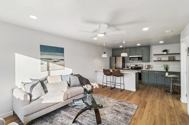 living room with ceiling fan and light hardwood / wood-style floors