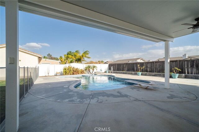 view of pool with ceiling fan, a diving board, and a patio