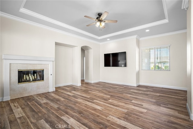 unfurnished living room featuring ceiling fan, ornamental molding, a fireplace, and a raised ceiling