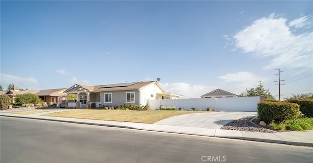 single story home with a front lawn and solar panels