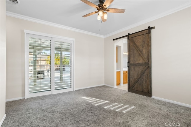 spare room with crown molding, a barn door, ceiling fan, and light colored carpet