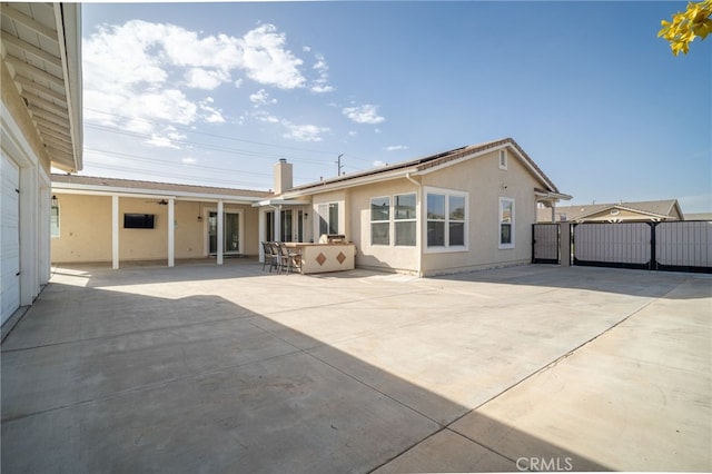 back of house with exterior bar and a patio