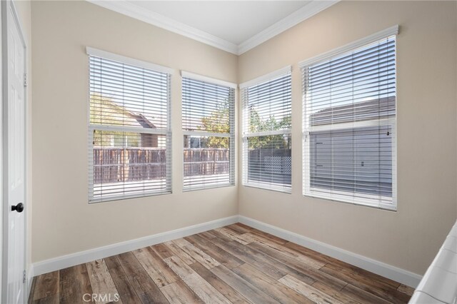 unfurnished room featuring hardwood / wood-style floors and ornamental molding