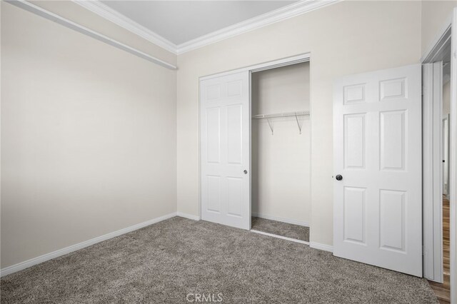 unfurnished bedroom featuring a closet, ornamental molding, and carpet floors