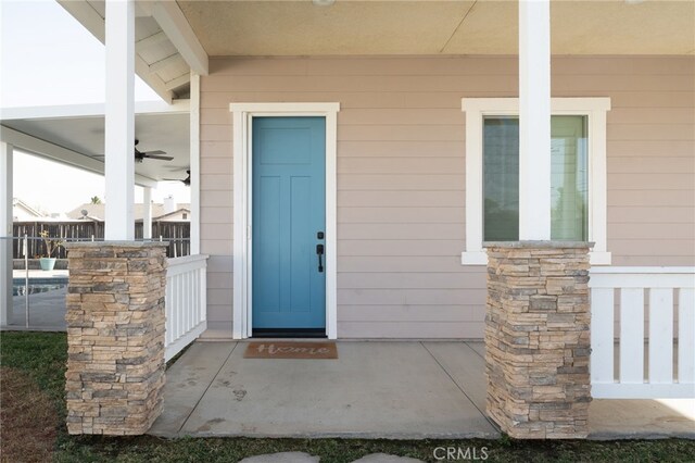 doorway to property featuring ceiling fan and covered porch