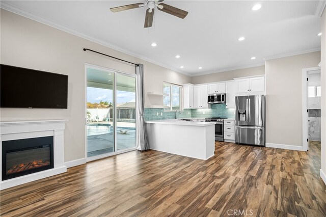 kitchen with dark wood-type flooring, white cabinets, appliances with stainless steel finishes, and kitchen peninsula