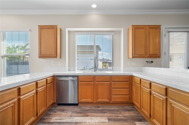 kitchen with tile counters, dishwasher, sink, and ornamental molding