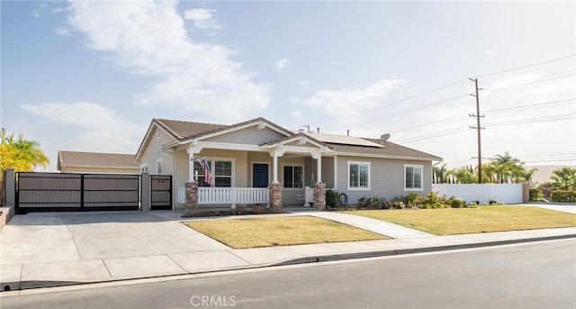 view of front of house featuring solar panels, a porch, and a front yard