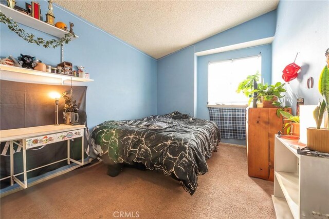 carpeted bedroom featuring vaulted ceiling and a textured ceiling