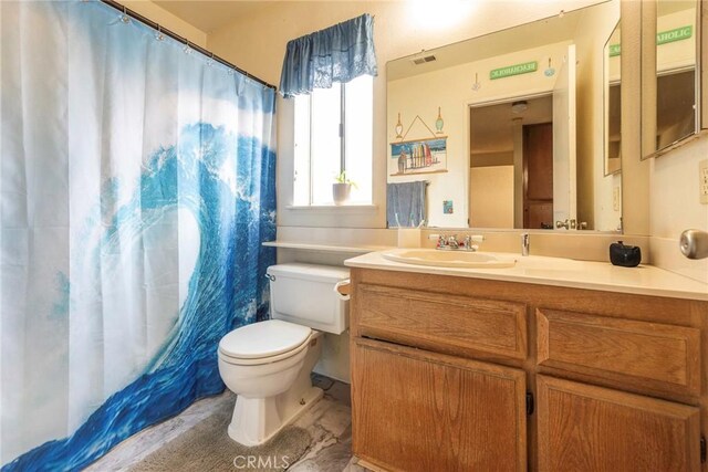 bathroom featuring toilet, vanity, and a shower with curtain