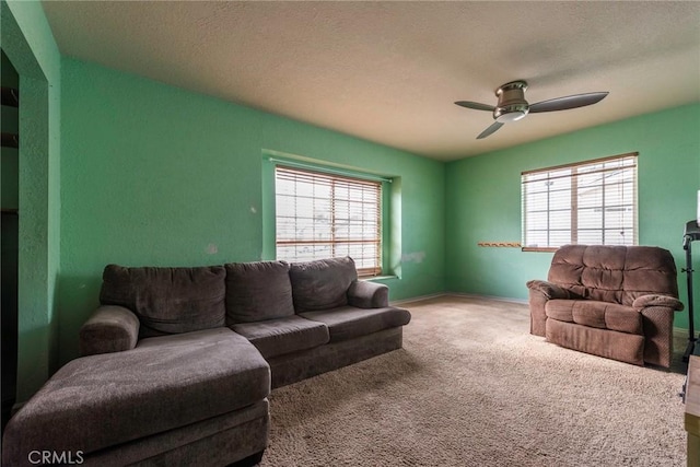 carpeted living room with ceiling fan, a wealth of natural light, and a textured ceiling