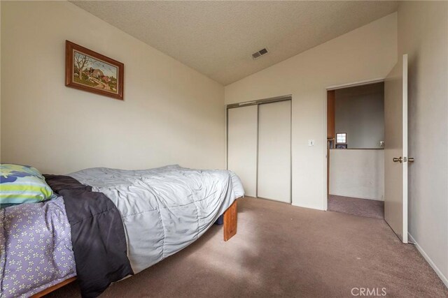 carpeted bedroom featuring lofted ceiling and a closet