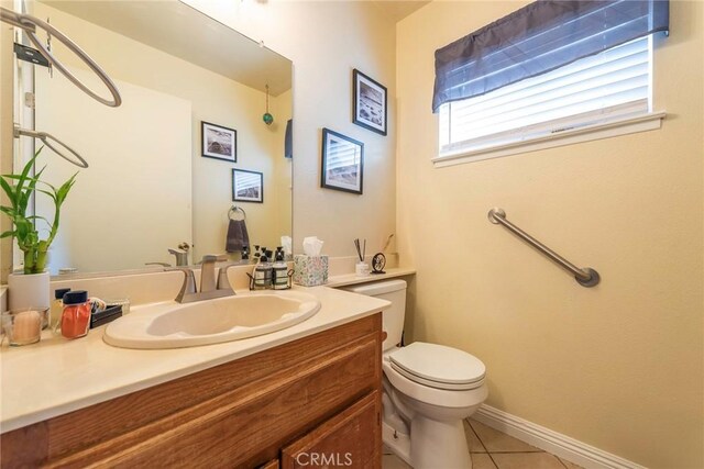 bathroom featuring toilet, vanity, and tile patterned flooring