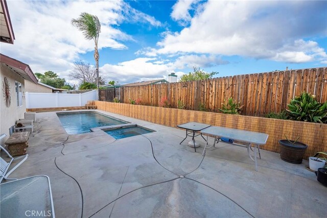 view of pool with a patio and an in ground hot tub