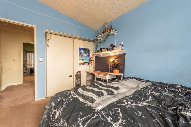 bedroom featuring a textured ceiling, a closet, lofted ceiling, and carpet flooring