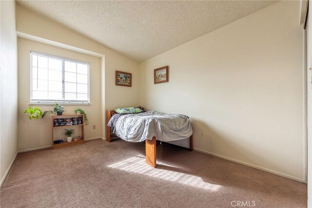 unfurnished bedroom with a textured ceiling, carpet flooring, and lofted ceiling