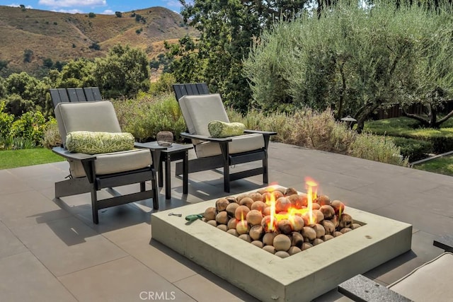 view of patio with a mountain view and an outdoor fire pit