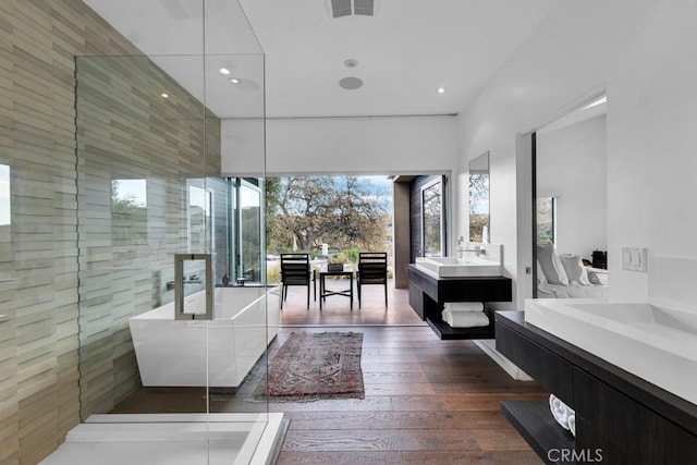 bathroom featuring a tile shower, hardwood / wood-style floors, and vanity