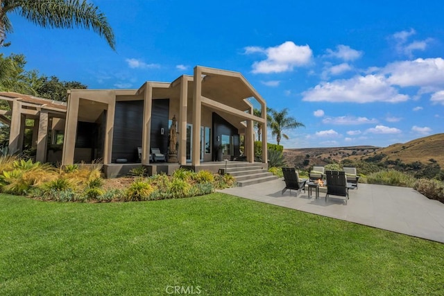 back of property with a patio area and a yard