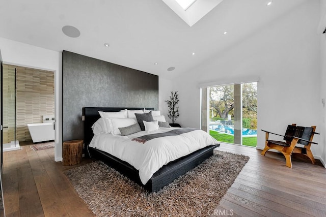 bedroom featuring access to outside, high vaulted ceiling, ensuite bathroom, and hardwood / wood-style floors