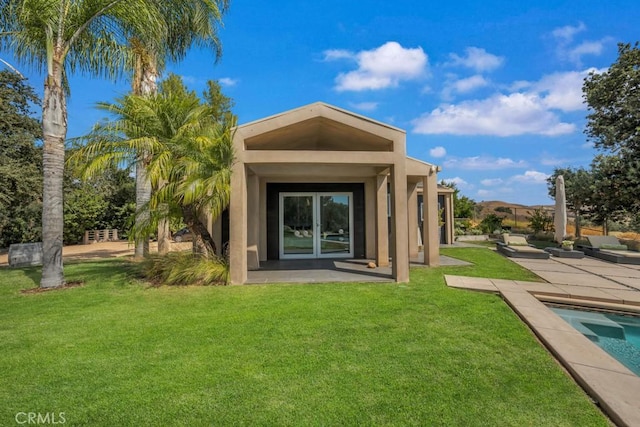 rear view of property with a patio and a yard