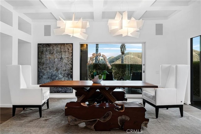 dining room with coffered ceiling, beam ceiling, a mountain view, and wood-type flooring