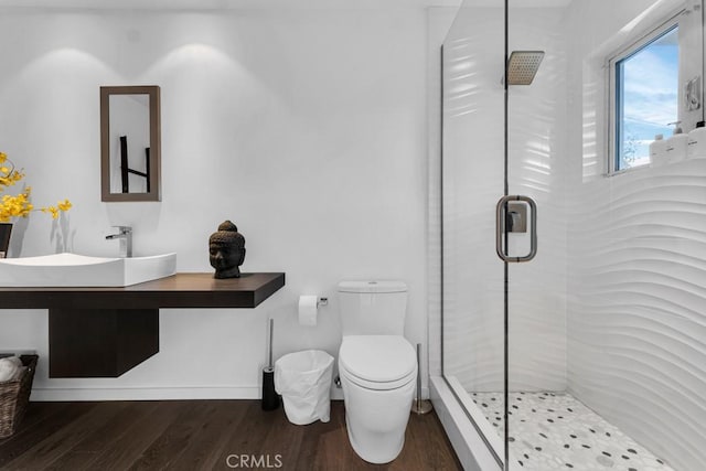 bathroom featuring toilet, vanity, wood-type flooring, and a shower with shower door