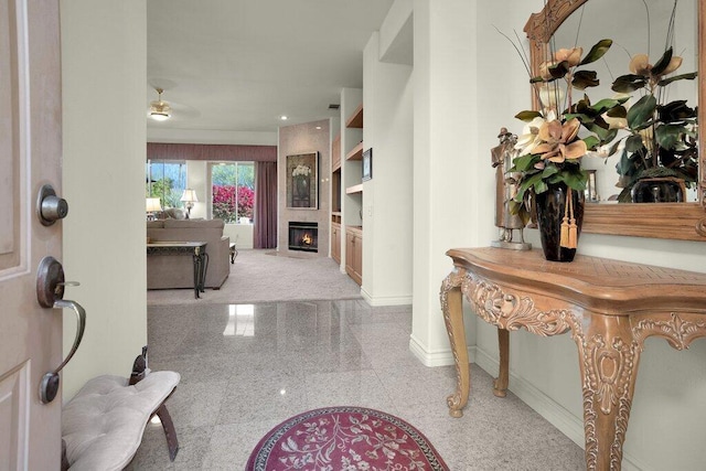 foyer with ceiling fan and a fireplace