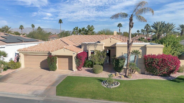 mediterranean / spanish-style house featuring a front yard and a garage