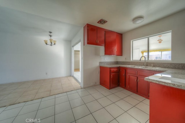 kitchen featuring light tile patterned flooring, an inviting chandelier, and sink