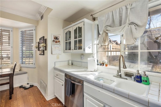 kitchen featuring sink, dishwasher, tile counters, and white cabinetry