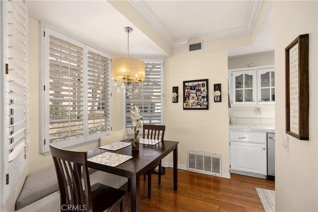 dining room featuring ornamental molding, a chandelier, and dark hardwood / wood-style flooring