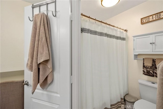 bathroom featuring a shower with shower curtain and toilet