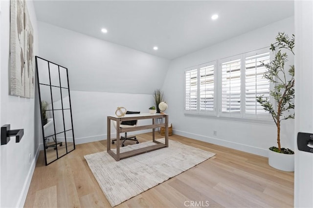 office space featuring light wood-type flooring and vaulted ceiling