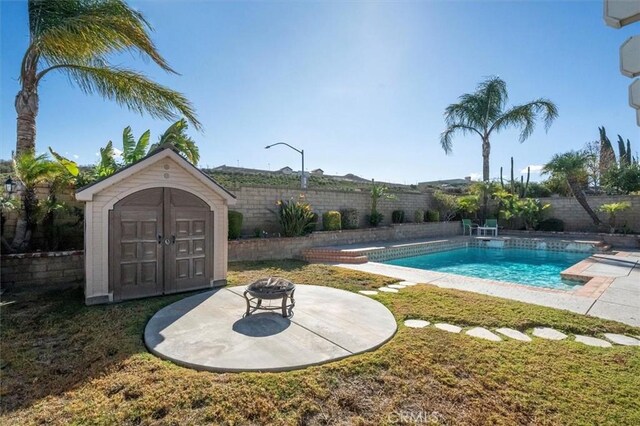 view of swimming pool featuring a lawn and a storage unit