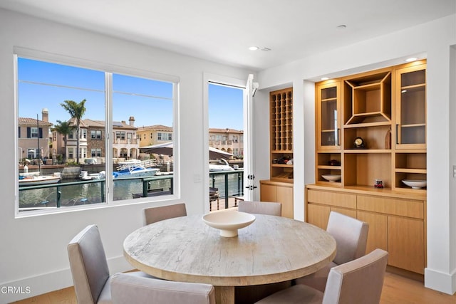 dining space featuring a water view and light wood-type flooring