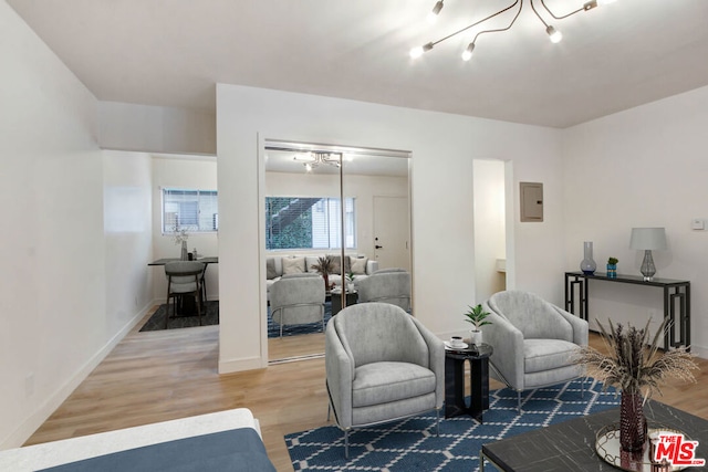 living area with hardwood / wood-style flooring and electric panel