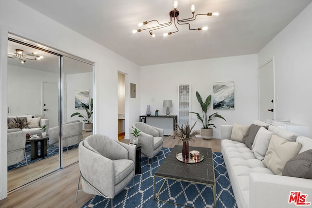 living room featuring hardwood / wood-style flooring, electric panel, and an inviting chandelier